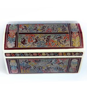 Fabricado con madera de lináloe, conocida por su aroma característico y duradero, el baúl no solo cautiva por su belleza visual, sino también por su fragancia envolvente. Al abrirlo, se libera un perfume suave que evoca la tierra, el bosque y la esencia de lo auténtico. Los detalles decorativos son verdaderamente impresionantes: motivos florales, animales míticos, grecas y símbolos tradicionales se entrelazan en una composición armoniosa, pintados a mano con pigmentos naturales y técnicas de lacado que requieren paciencia, precisión y maestría. Algunos diseños están grabados con espinas de maguey, lo que añade textura y profundidad a la superficie, creando una experiencia táctil única. Este baúl no solo es un contenedor de objetos; es un guardián de memorias. Su tamaño generoso permite almacenar desde textiles y documentos hasta piezas valiosas o recuerdos personales. Es ideal como pieza decorativa en salas, estudios o recámaras, donde se convierte en un punto focal que despierta admiración y conversación. Regalar o adquirir un baúl de Olinalá es apostar por lo auténtico, por el arte que nace de la tierra y se transforma en legado. Es una forma de honrar el trabajo de manos expertas que, con dedicación y amor, preservan una tradición que resiste al paso del tiempo. Cada baúl es único, irrepetible y profundamente simbólico. Es más que un objeto: es una expresión de identidad, belleza y respeto por nuestras raíces. Llevarlo a casa es abrir espacio a la historia, al arte y al alma de México.