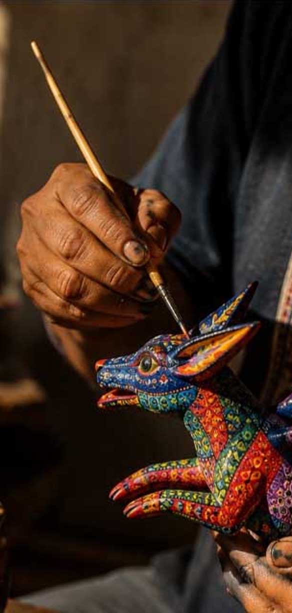 Recorte de artesano pintando alebrije